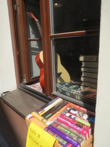 Kirjallisen kuppilan ikkunaopuksista paljastuu teksti: "BRING BOOKS WE´LL PUT IT IN USE."