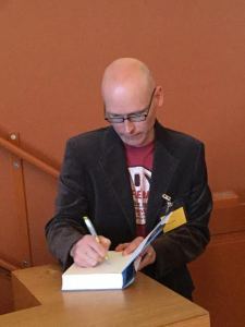 Jussi Valtonen signeeraamassa voittokirjaansa.