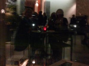 Väliaika: oopperanautiskelijat iltaikkunaan heijastuen.